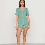 Woman wearing a green pajama set against a white background