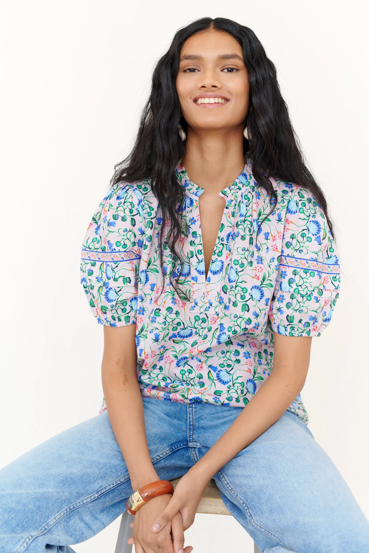woman in floral blouse and denim on white background 