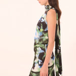 Woman wearing a sleeveless dress with a floral pattern on a white background