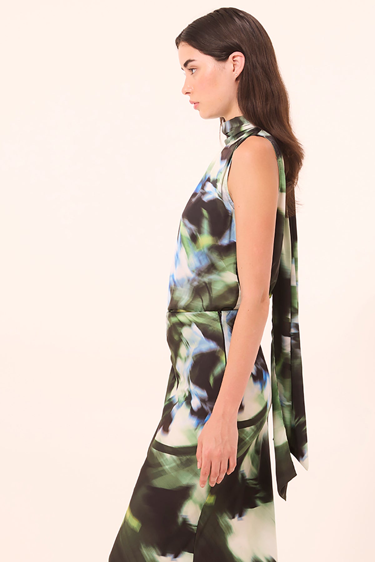 Woman wearing a sleeveless dress with a floral pattern on a white background