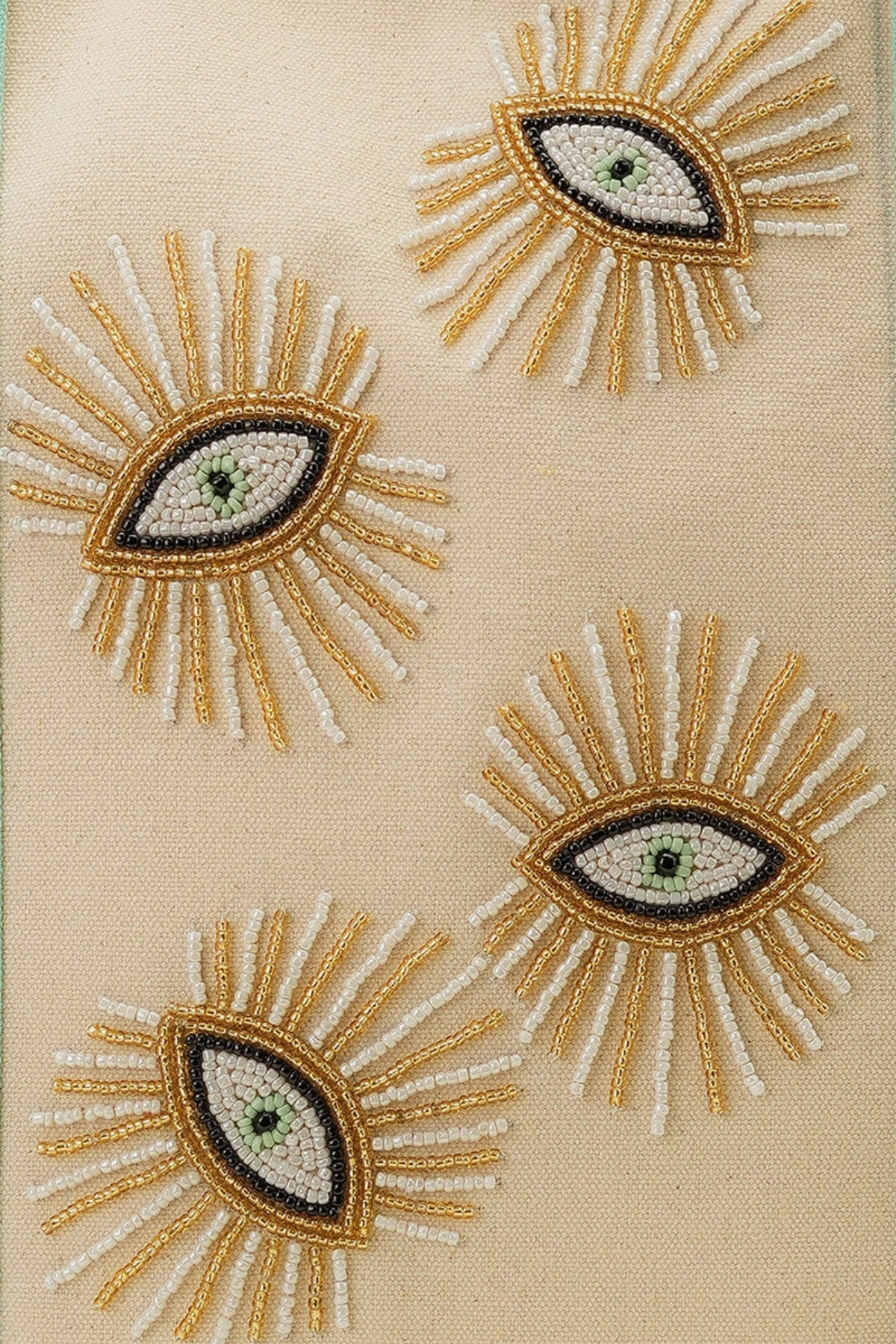 Embroidered eye designs on a beige fabric background