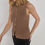 A woman wearing a sleeveless ribbed knit vest in taupe brown with gold-tone buttons, paired with black pants, photographed against a plain light gray studio background.