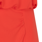 Close-up of a red garment with a textured pattern on a white background