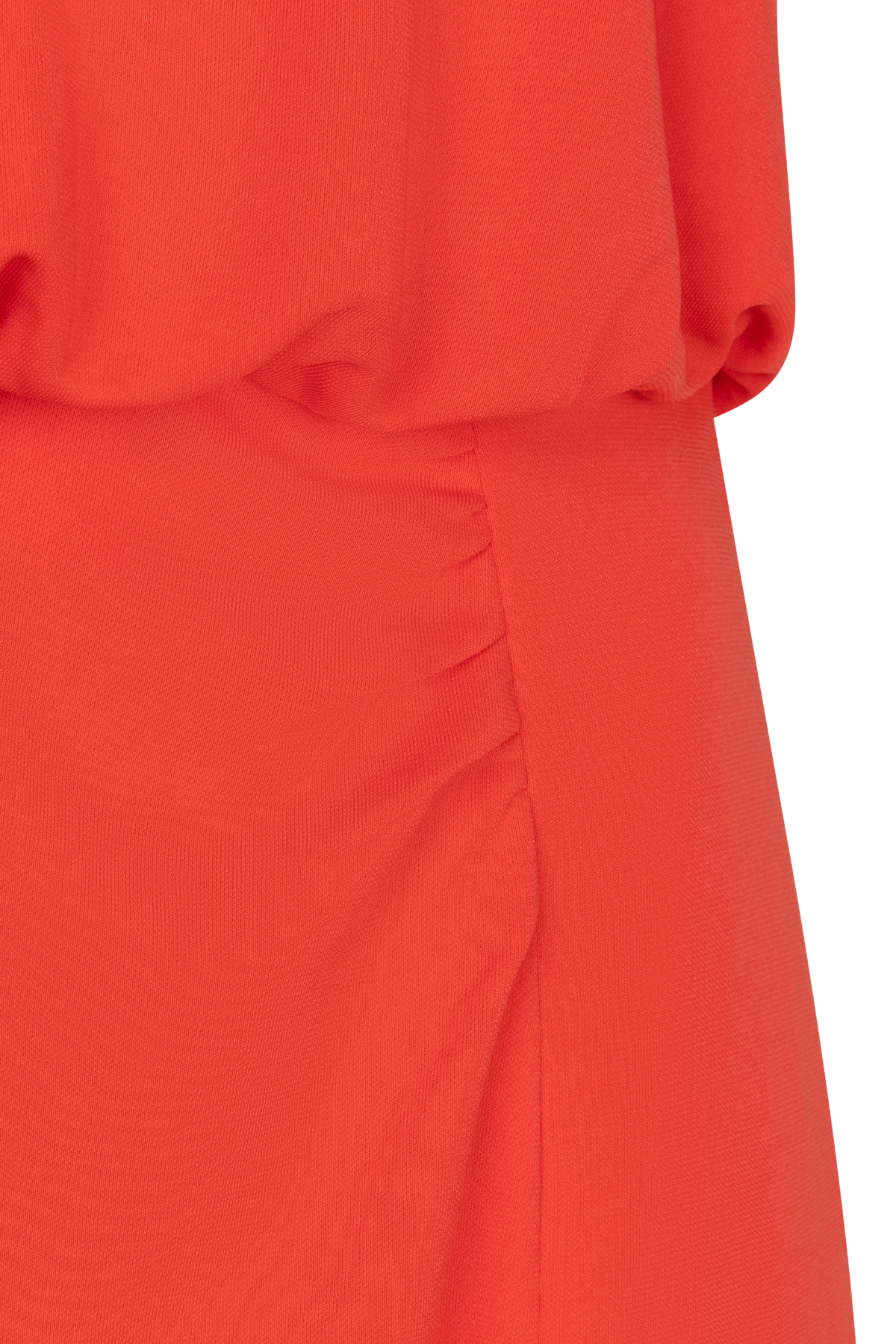 Close-up of a red garment with a textured pattern on a white background