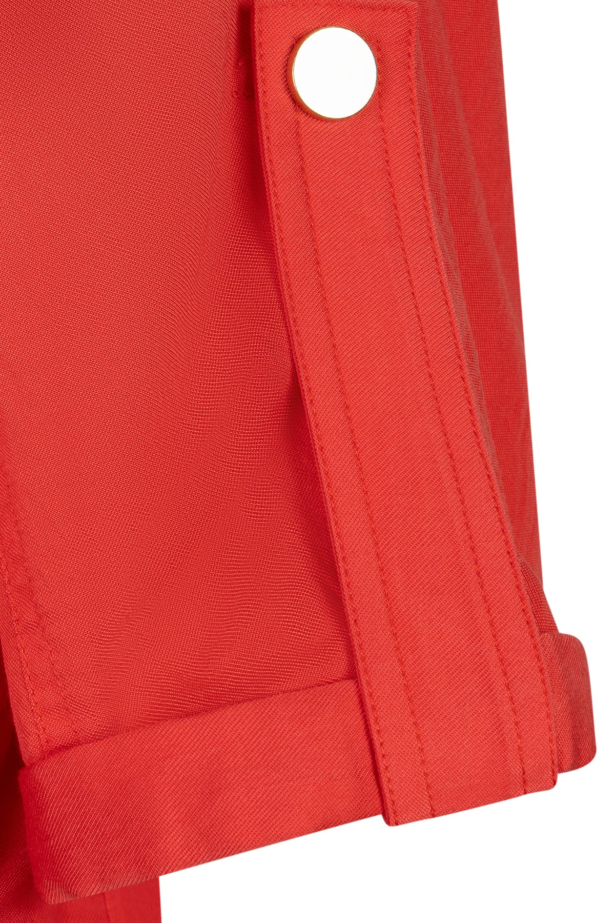 Close-up of a red jacket with a button on a white background