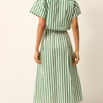 Woman wearing a green and white striped skirt on a plain background