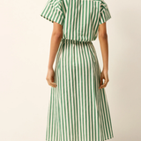 Woman wearing a green and white striped skirt on a plain background