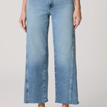 Person wearing light blue jeans on a plain background