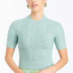 Woman wearing a soft mint cable knit sweater with a smooth, lightweight knit and polished neckline