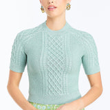 Woman wearing a soft mint cable knit sweater with a smooth, lightweight knit and polished neckline