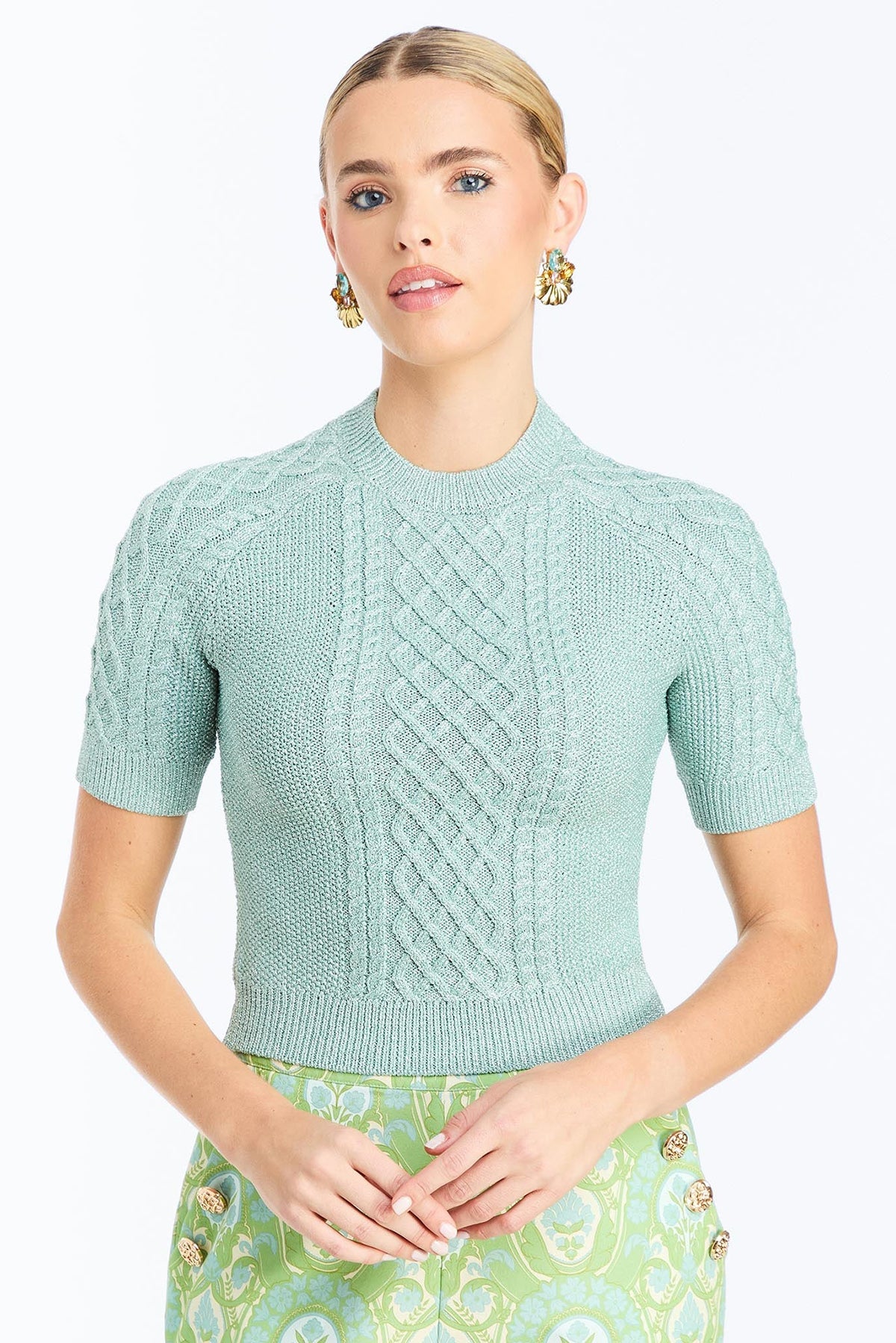 Woman wearing a soft mint cable knit sweater with a smooth, lightweight knit and polished neckline