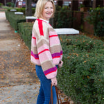 Striped knit cardigan worn open over a simple top