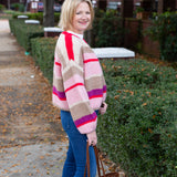 Striped knit cardigan worn open over a simple top