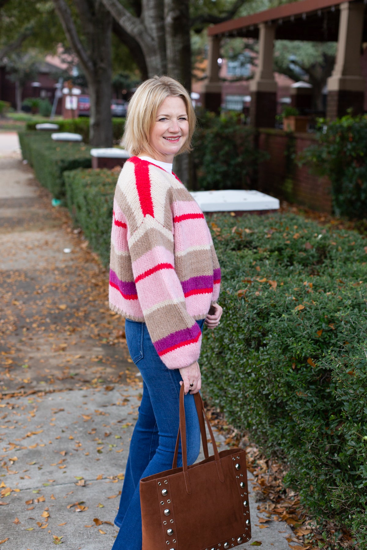 Striped knit cardigan worn open over a simple top