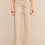A model wearing beige wide-leg cropped pants with a tan belt and a gold buckle, paired with an olive green top and green suede boots, against a solid beige background.