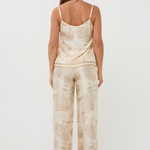 Woman wearing a beige patterned jumpsuit on a white background