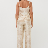 Woman wearing a beige patterned jumpsuit on a white background
