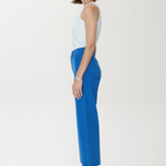 Woman wearing a white top and blue pants on a white background