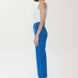 Woman wearing a white top and blue pants on a white background