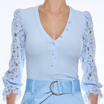 woman in light blue blouse with lace sleeves 