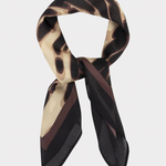 A lightweight silk scarf with an abstract organic pattern in black, dark brown, and beige, styled in a loop on a light gray background.