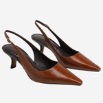 A pair of brown pointed-toe slingback pumps with a textured finish and low kitten heels, shown on a light gray background.