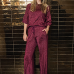 Women's burgundy lurex knit trousers featuring a relaxed full-length silhouette and subtle metallic shimmer.