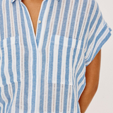 Blue and white striped shirt worn by a person on a plain background