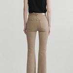 A model shown from the back wearing beige flared jeans, a black sleeveless top, and black heels against a light gray studio background.