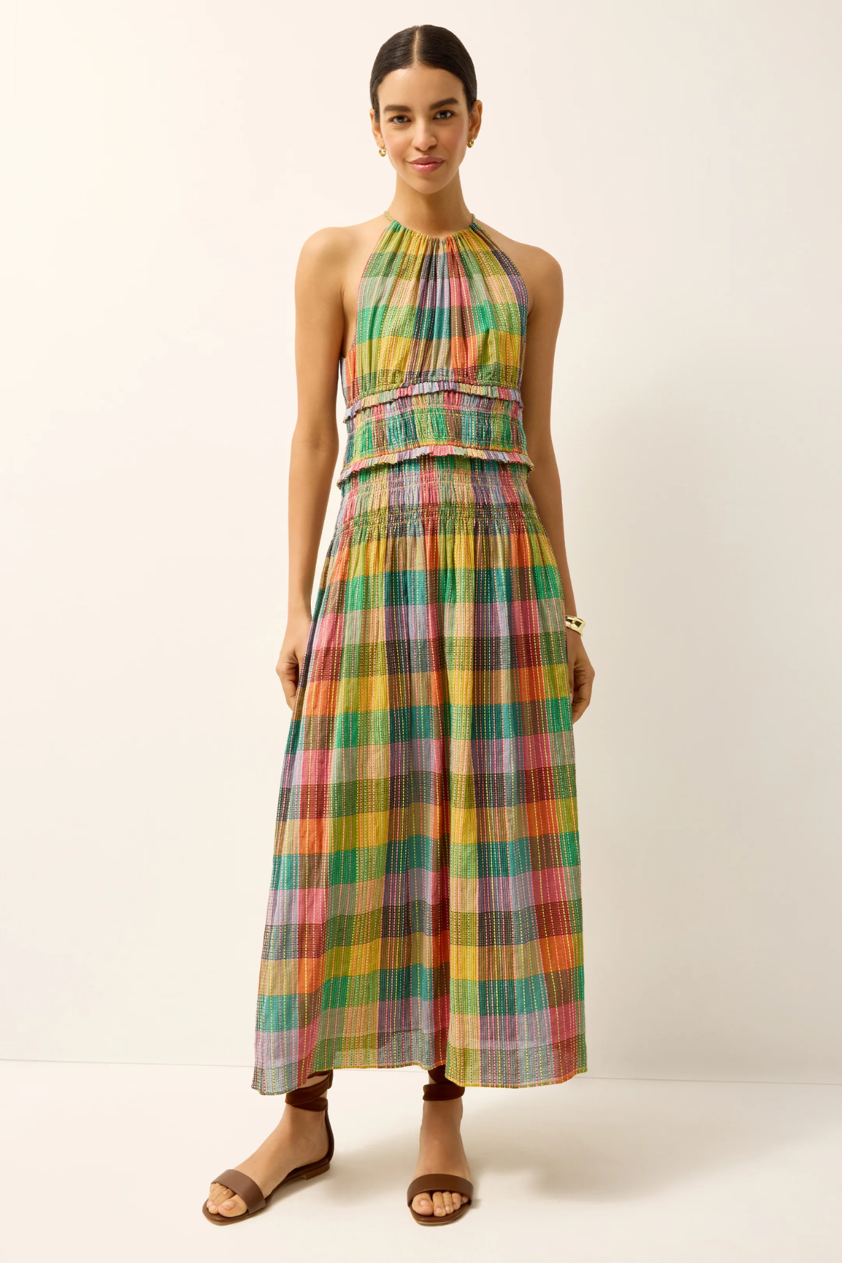 Woman wearing a colorful plaid dress on a white background
