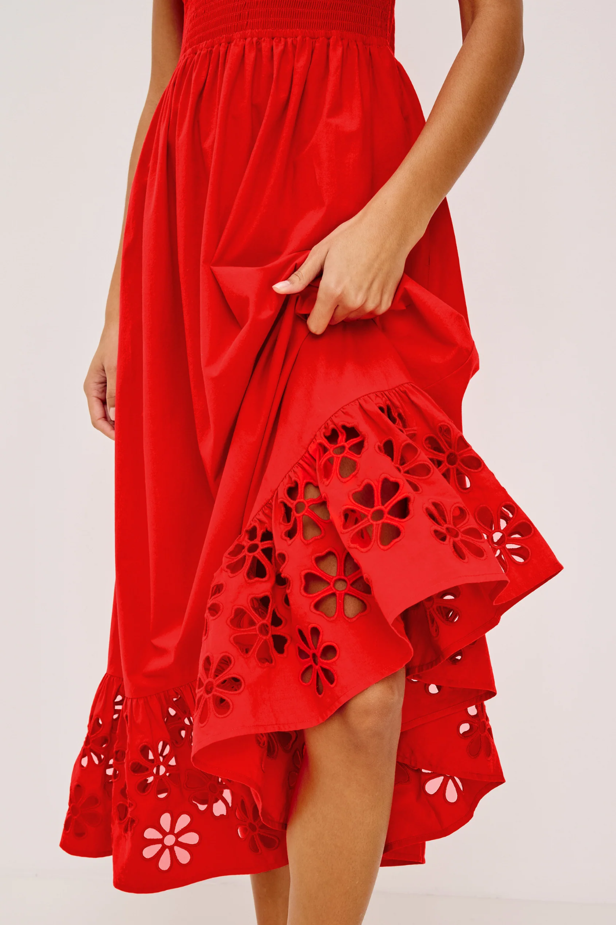 Red dress with floral cut-out details on a white background