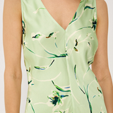 Green dress with floral pattern worn by a person on a white background