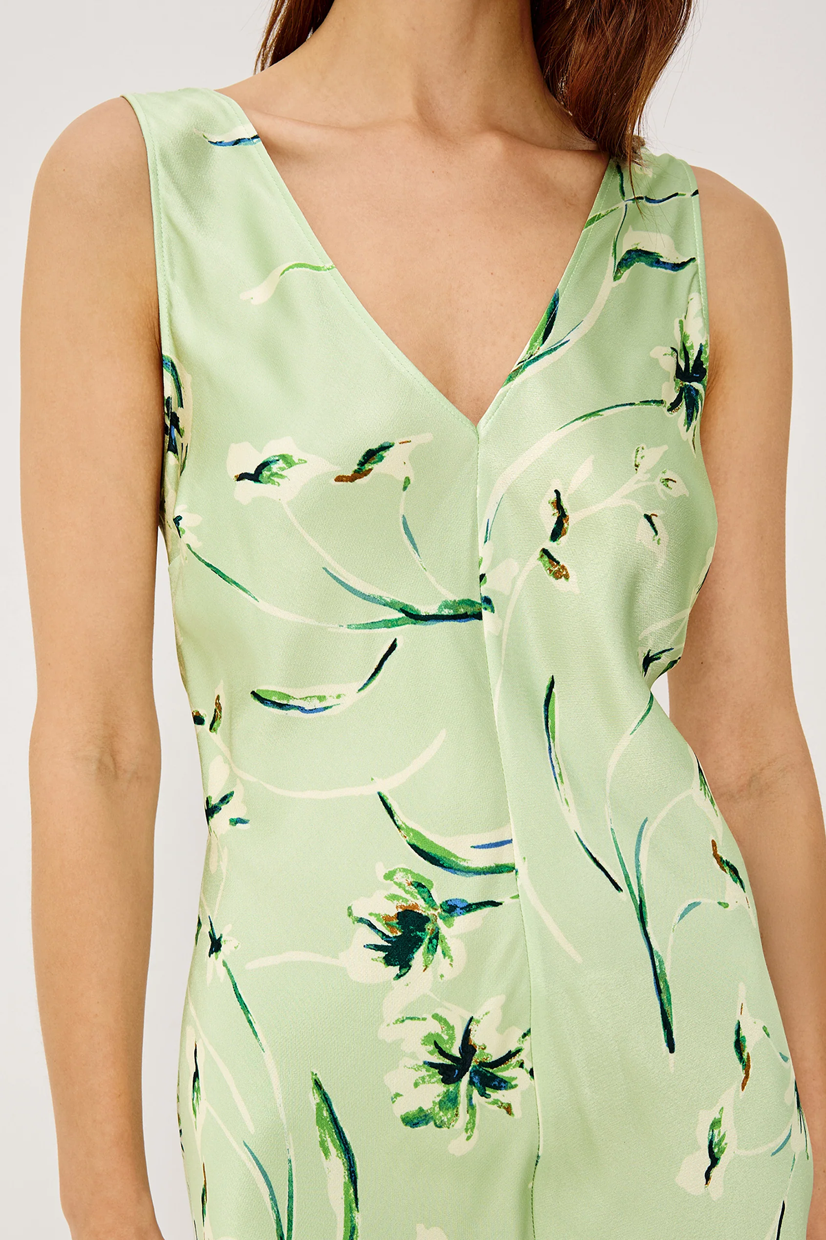 Green dress with floral pattern worn by a person on a white background