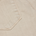 Close-up of beige fabric with a pocket detail