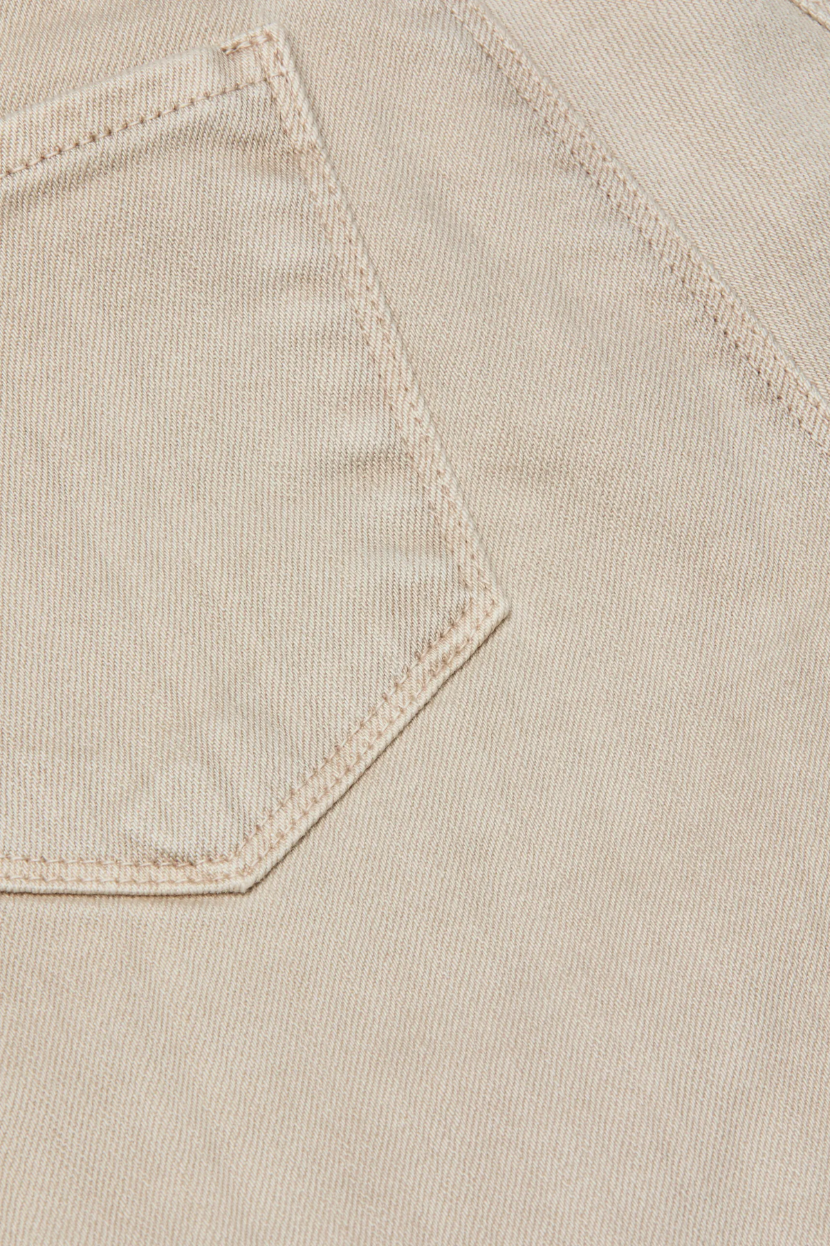 Close-up of beige fabric with a pocket detail