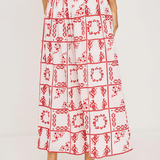 Person wearing a red and white patterned skirt on a plain background