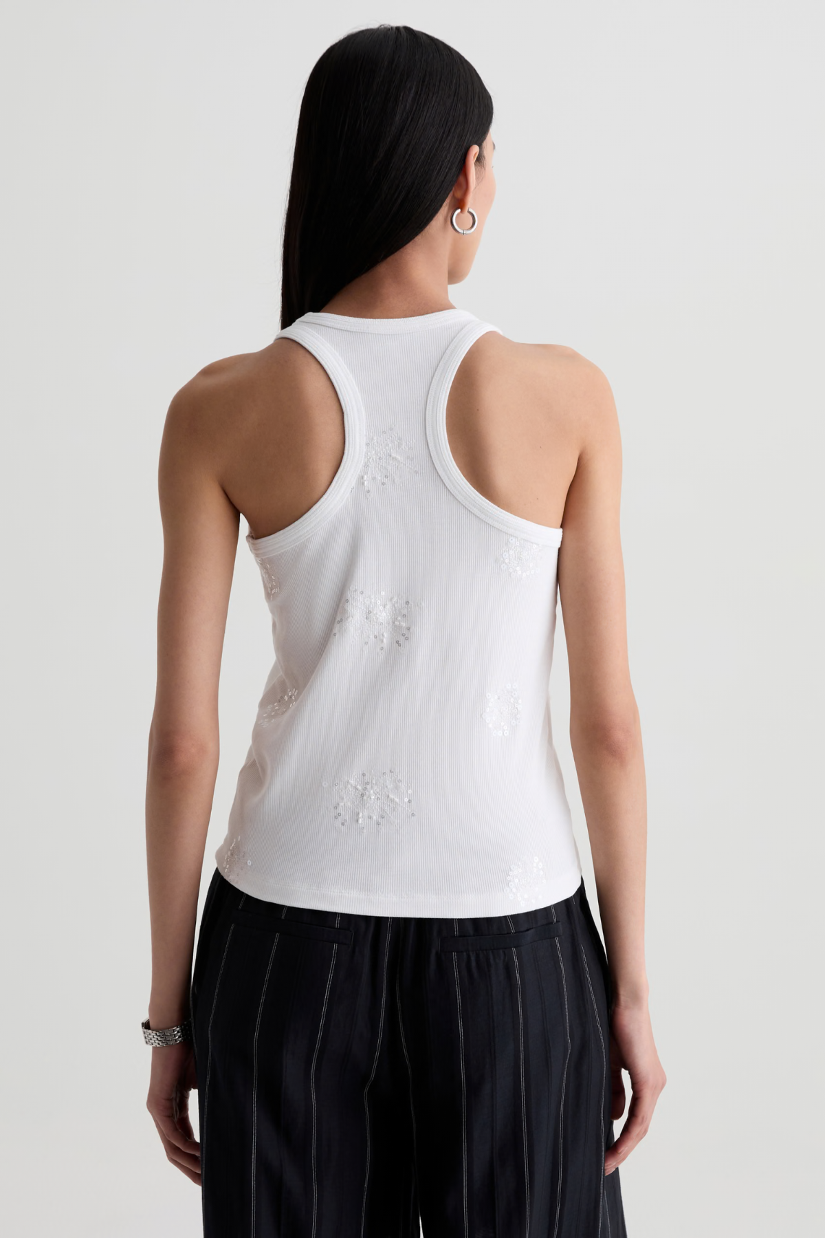 Model wearing a versatile solid-color top with a flattering silhouette styled with tailored black pants.