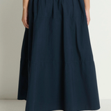 Navy blue skirt worn by a person on a plain background