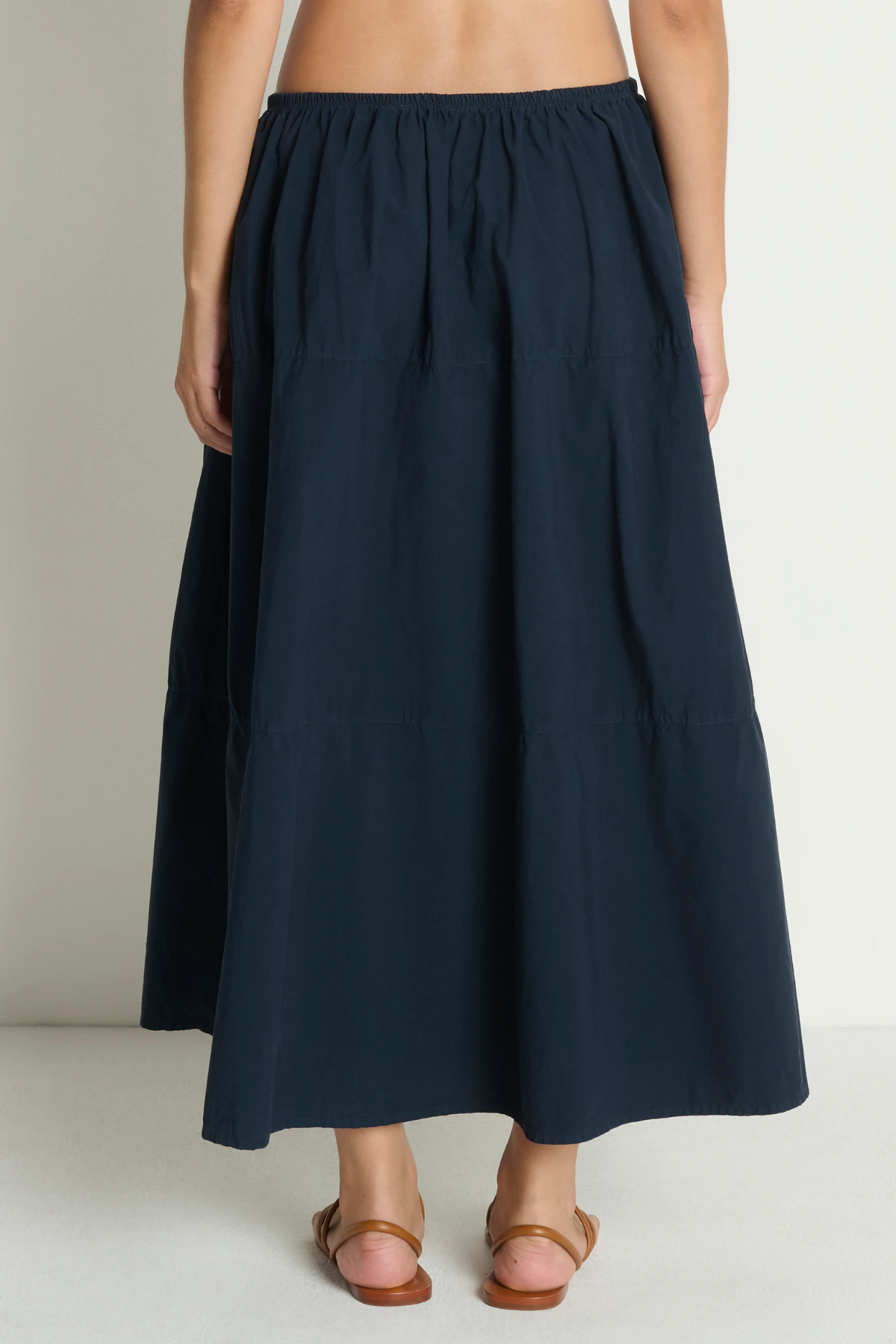 Navy blue skirt worn by a person on a plain background