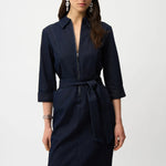 Woman wearing a indigo denim  dress with a belt on a white background