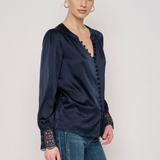 Model wearing a long-sleeve blouse with delicate lace detailing and a flattering tailored silhouette.