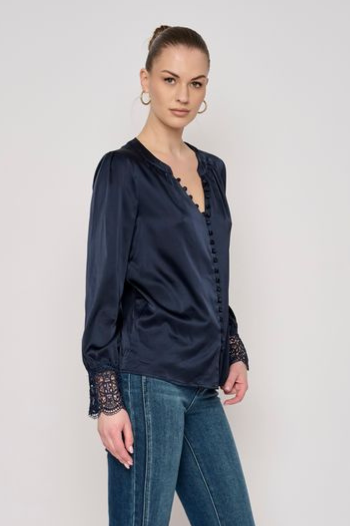 Model wearing a long-sleeve blouse with delicate lace detailing and a flattering tailored silhouette.