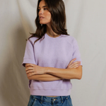 woman in short sleeve purple top on draped background 