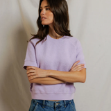 woman in short sleeve purple top on draped background 