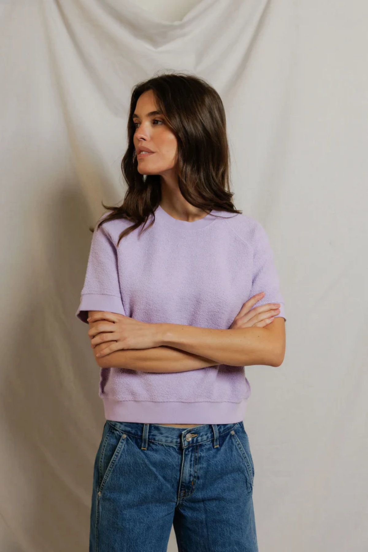 woman in short sleeve purple top on draped background 