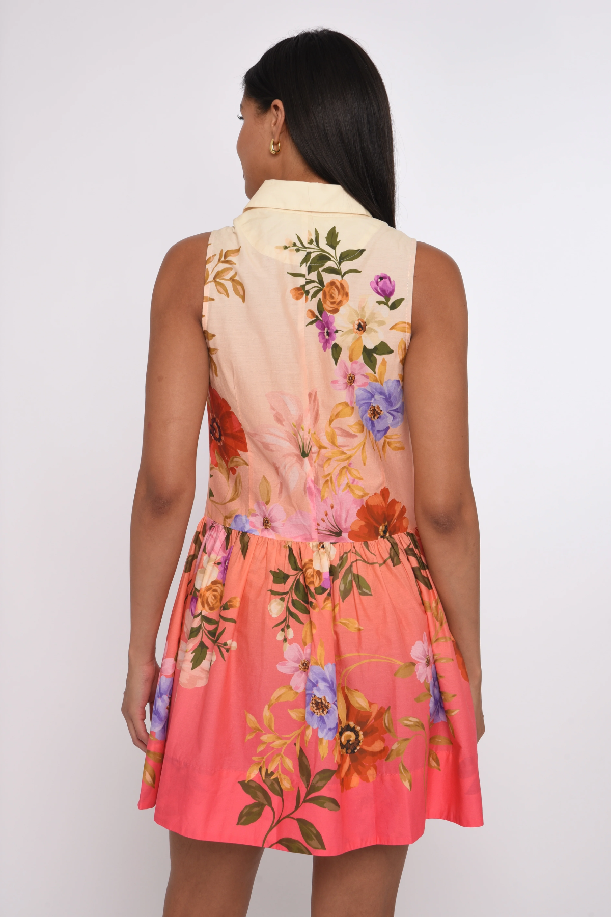 Woman wearing a colorful floral dress with a white background