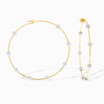 Gold hoop earrings with pearl-like beads on a white background