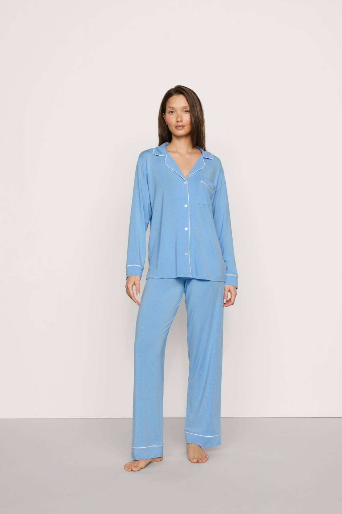 Woman wearing a light blue pajama set against a white background