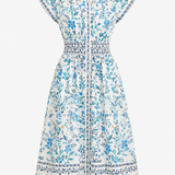 A white short-sleeve button-front dress with a blue and teal floral print, featuring a smocked waist and a decorative border along the hem.