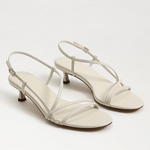 Pair of white high-heeled sandals on a light gray background